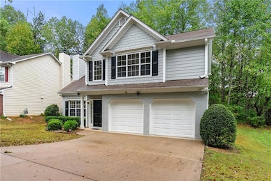Traditional-style home featuring driveway, roof with shingles, and a front yard