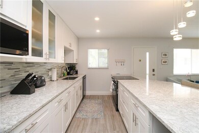 Kitchen featuring sink, white cabinetry, light sto