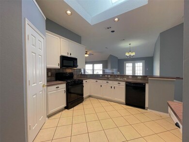Kitchen with kitchen peninsula, white cabinetry, s