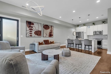 Living area with dark wood finished floors and recessed lighting