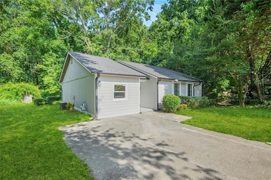 Single story home featuring a front yard, driveway, and roof with shingles