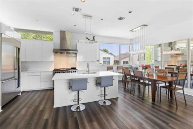 Kitchen with wall chimney range hood, a sink, sta