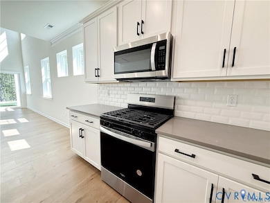 Stepping inside, you’ll travel through the inviting foyer to the kitchen which features a center island, quartz countertops, gas cooking, and a walk-in pantry. 
