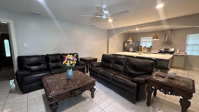 Living room featuring ceiling fan, arched walkways, and light tile patterned flooring