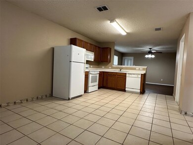 Kitchen with white appliances, visible vents, a peninsula, a sink, and light countertops