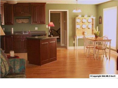 View of open floor plan of this pretty home. Living room & dining area has laminate flooring. Kitchen has tiled floor.