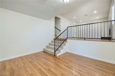 Staircase with wood finished floors and recessed l