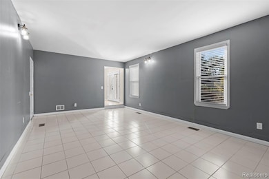Spare room with baseboards and light tile patterned floors