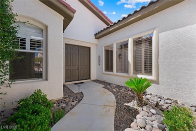 View of exterior entry with stucco siding and a tiled roof