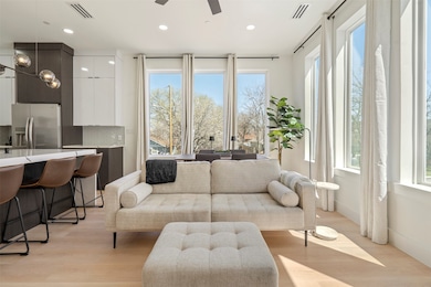 Living room with light wood finished floors, visible vents, and recessed lighting