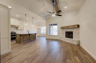 Living room featuring a stone fireplace, light har
