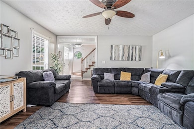 Living area featuring a ceiling fan, stairs, a tex