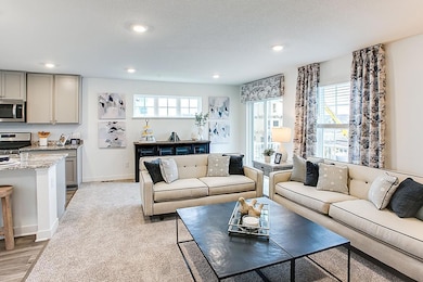 View of the large family room. Model picture shown. Colors and finishes may vary. Subject address is an interior unit. Exterior unit photos shown.