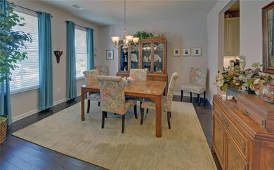 Dining area with a chandelier, healthy amount of natural light, and dark wood-type flooring