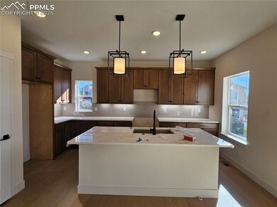 Kitchen featuring an island with sink, decorative backsplash, wood finished floors, hanging light fixtures, and recessed lighting