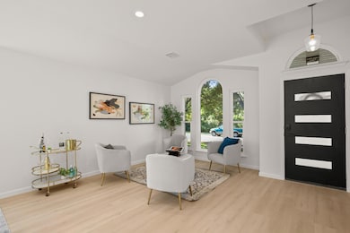 Foyer featuring light wood-type flooring, lofted ceiling, and recessed lighting