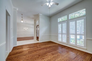 Study with plantation shutters hardwood flooring.