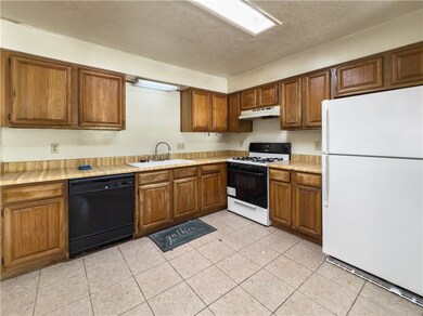Kitchen with white appliances, a sink, under cabin