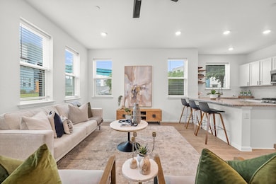 Living area with light wood finished floors, recessed lighting, and ceiling fan