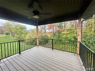 Wooden deck featuring a ceiling fan and a lawn