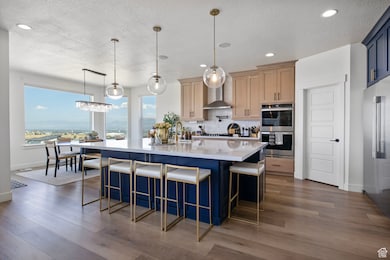 Kitchen with pendant lighting, light stone counters, a breakfast bar area, blue cabinets, and decorative backsplash