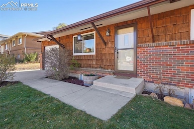 Doorway to property featuring a lawn and a garage