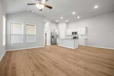 Unfurnished living room with light wood-style floors, a ceiling fan, vaulted ceiling, and recessed lighting