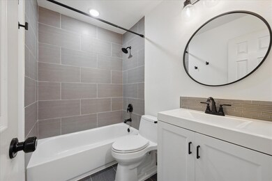 Full bathroom with decorative backsplash, toilet,