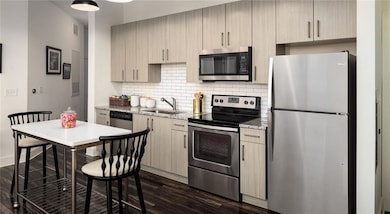 Kitchen featuring light brown cabinetry, appliance