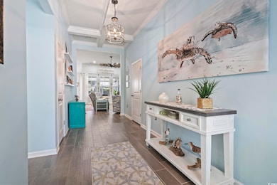 Hall featuring ornamental molding, a chandelier, d