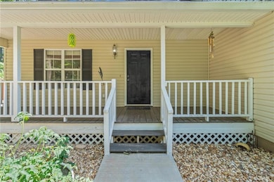 Doorway to property featuring covered porch
