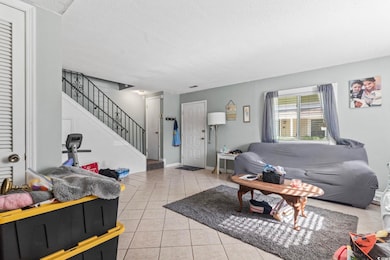 Living area with stairway, baseboards, a textured 