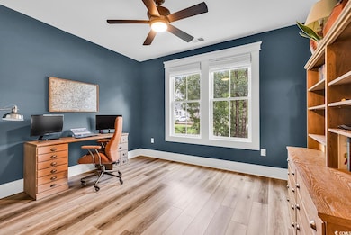 Office area featuring a ceiling fan, light wood-type flooring, and baseboards