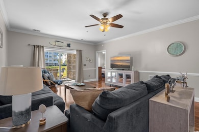 Living room featuring ornamental molding, wood finished floors, and a ceiling fan
