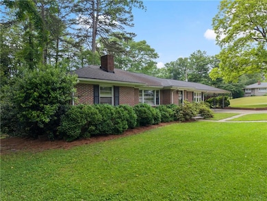 View of front of home with a chimney, brick siding