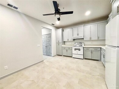 Kitchen featuring white appliances, tasteful backsplash, light countertops, a ceiling fan, and under cabinet range hood