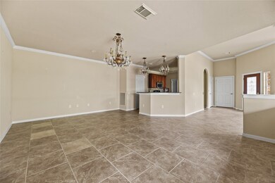 Elegant dining area with stylish tile flooring, sophisticated chandeliers, and seamless access to the kitchen for effortless entertaining.