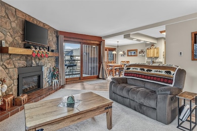 Living room with a stone fireplace and tile patterned flooring