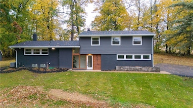 View of front facade with central air condition unit and a front lawn