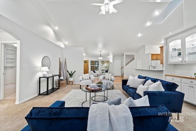 Living room featuring light colored carpet, recessed lighting, a ceiling fan, and arched walkways