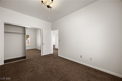 Unfurnished bedroom featuring dark colored carpet,