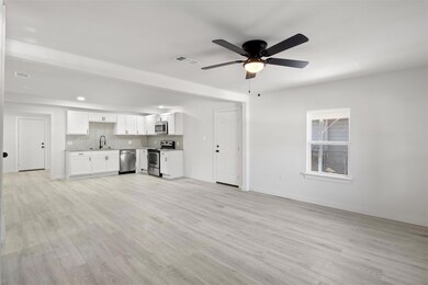 Unfurnished living room with ceiling fan, sink, an