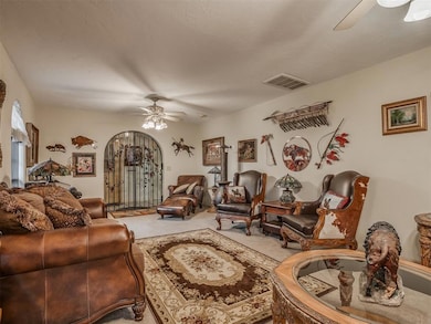 Carpeted living room featuring visible vents and a