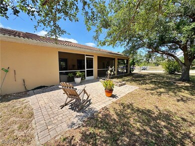 Back of house with a tiled roof, a sunroom, a yard