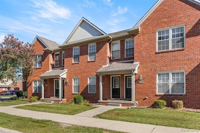 View of front of house with brick siding, a front yard, and a shingled roof