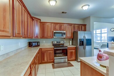 Hard Surface Counter Tops, Two walls of Cabinets, Island with Sink, Stainless Steel Refrigerator Stays AS IS.  Stainless Steel Stove. Walk In Pantry.