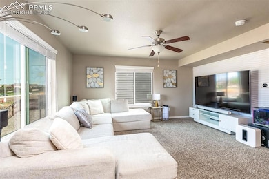 Living room featuring ceiling fan, carpet flooring, and baseboards