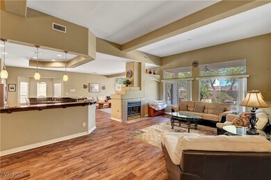 Living room with a fireplace, visible vents, baseb