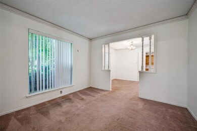 Unfurnished room featuring carpet, a notable chandelier, crown molding, and a textured ceiling