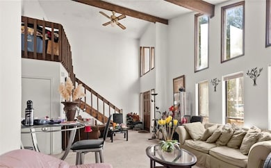 Living room featuring carpet floors, beam ceiling,